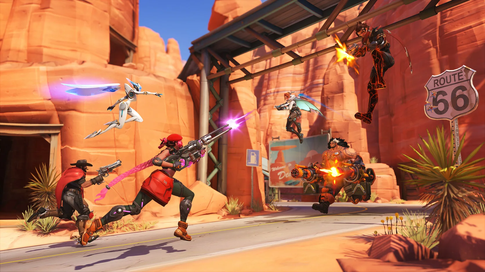 Overwatch 2 gameplay showing two teams fighting around Route 66 with several heroes using abilities