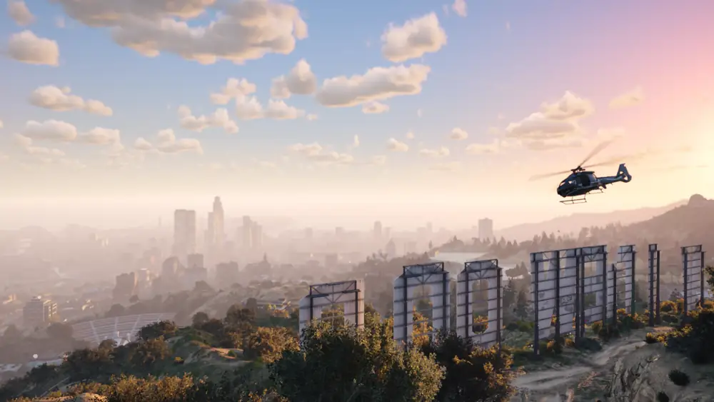 Helicopter above the VINEWOOD sign at sunset, with the Los Santos skyline beyond